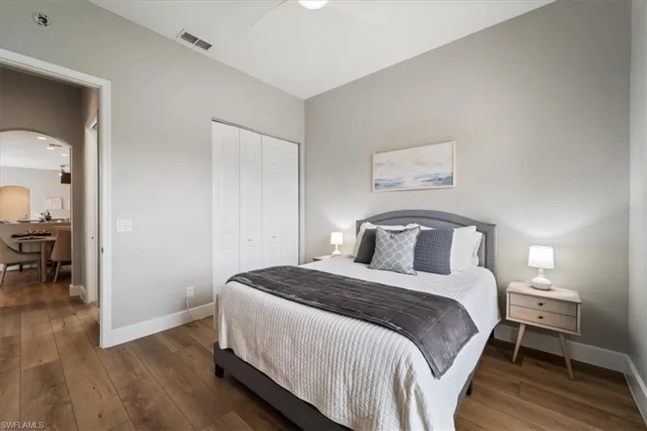 Bedroom featuring arched walkways, a closet, visible vents, and hardwood / wood-style flooring