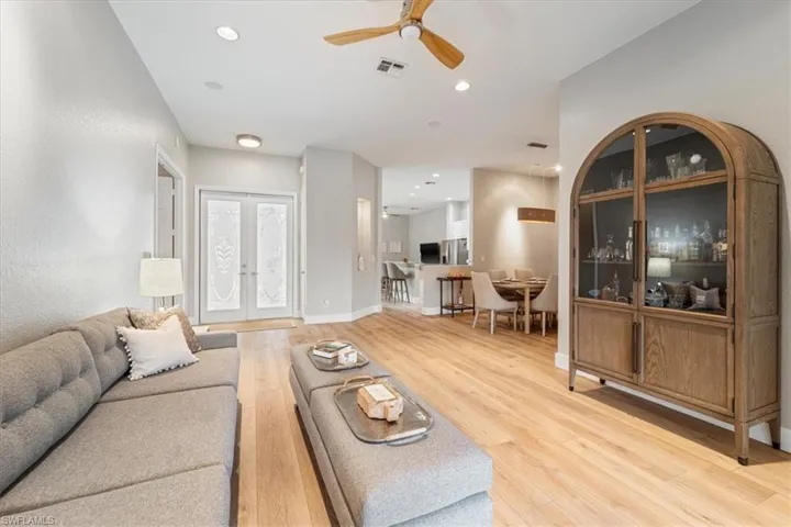 Living area featuring light wood finished floors, recessed lighting, visible vents, and french doors