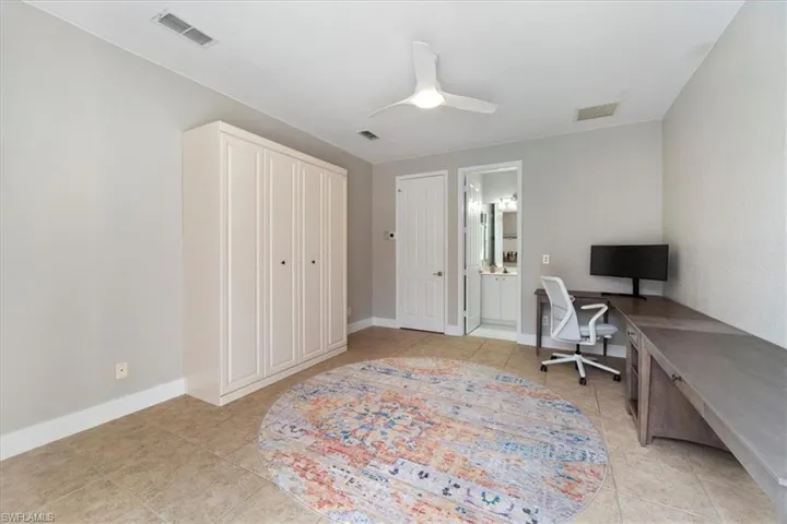 Office space featuring ceiling fan, light tile patterned flooring, visible vents, and baseboards