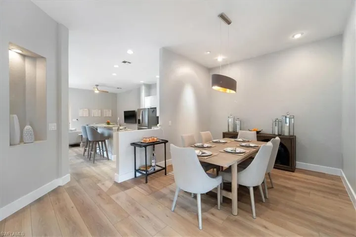 Dining room with light wood-style floors, baseboards, and recessed lighting