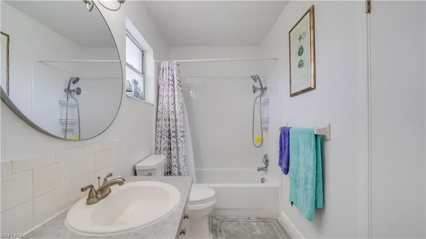 Built-in vanity with an integrated sink, brushed nickel faucet, and a large circular mirror