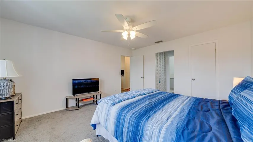 Carpeted flooring, white walls, and a ceiling fan with integrated lighting