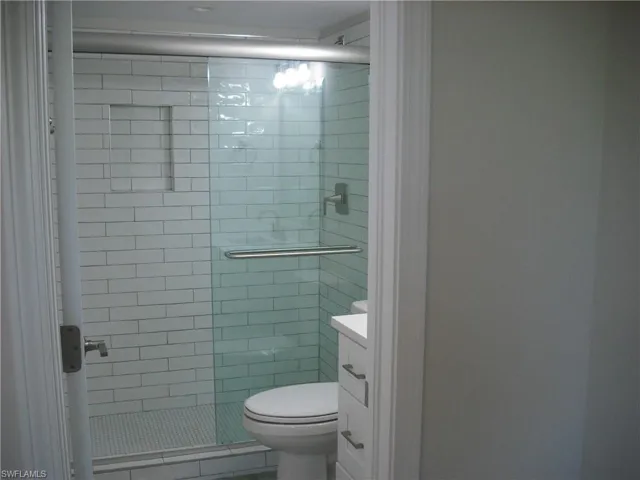 Full bath featuring toilet, a stall shower, and vanity