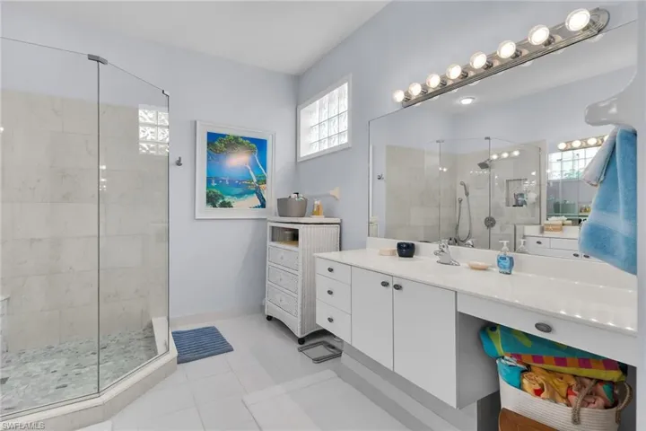 Bathroom featuring vanity, a shower stall, and light tile patterned flooring