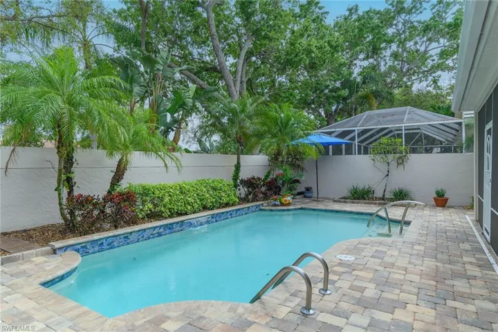 View of pool featuring patio surround, a fenced backyard, and a sunroom