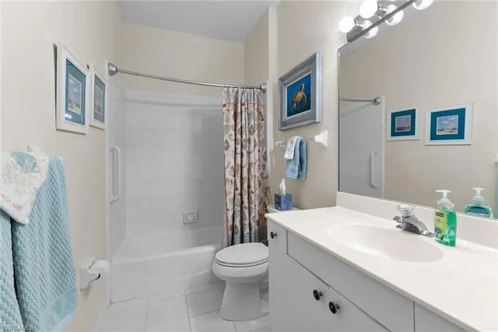 Bathroom featuring vanity, shower / tub combo, and light tile patterned floors