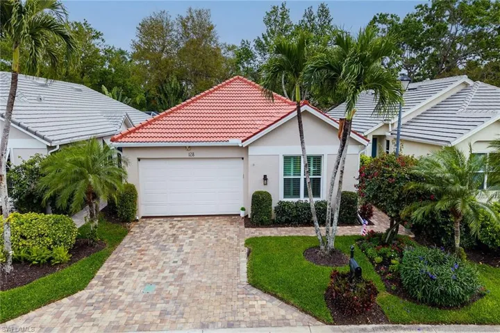 Single story home featuring an attached garage, stucco siding, decorative driveway, and a tile roof