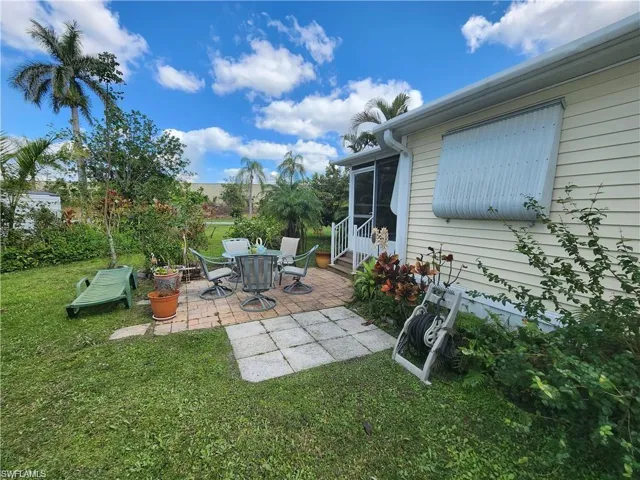 View of patio / terrace featuring a sunroom, entry steps, and outdoor dining space