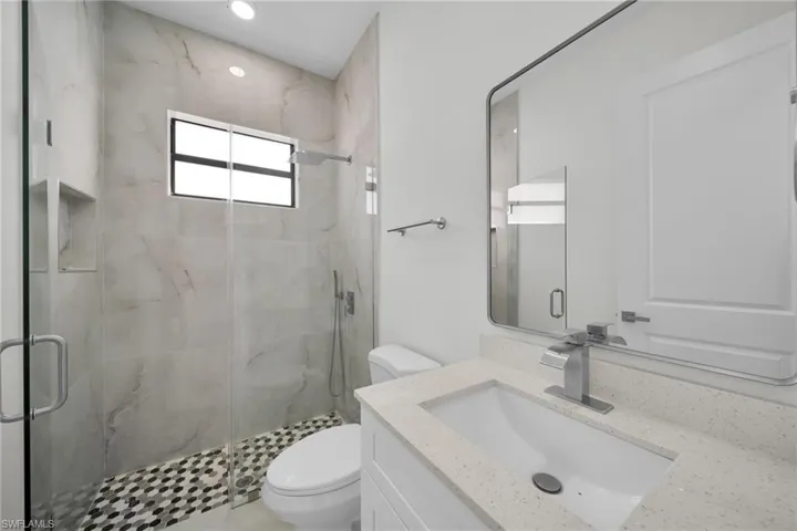 Full bath featuring vanity and a marble finish shower