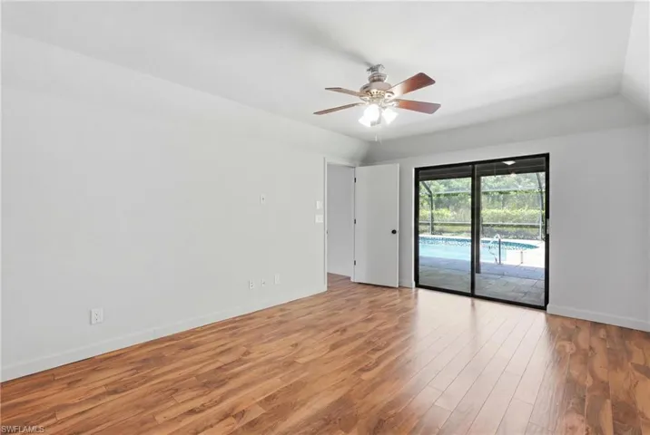 Spacious room featuring wood-finish flooring and a ceiling fan with integrated lighting