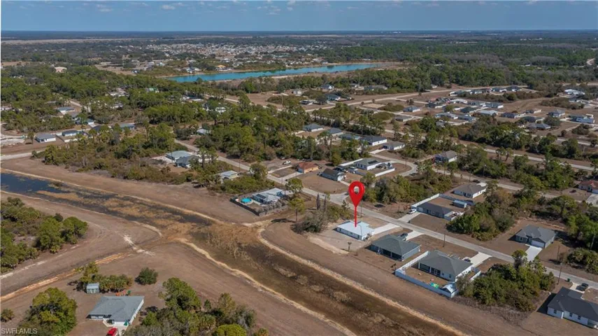 Aerial view of property and surrounding area featuring nearby suburban area