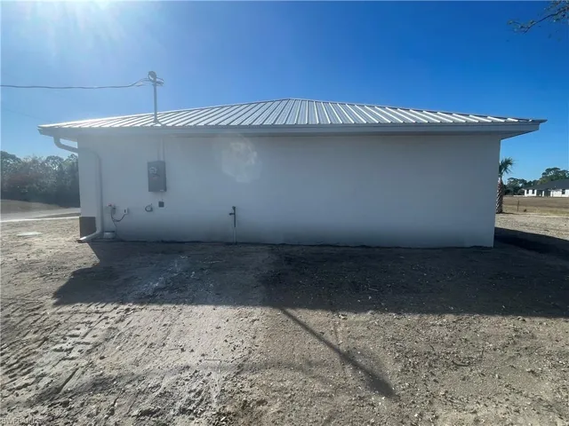 View of side of property with a metal roof and stucco siding
