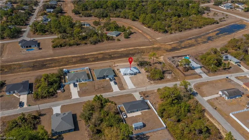 Aerial view of property and surrounding area featuring nearby suburban area