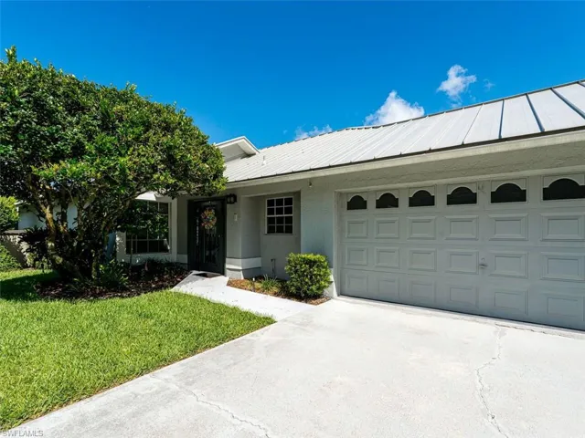 Single story home featuring a garage and a front yard