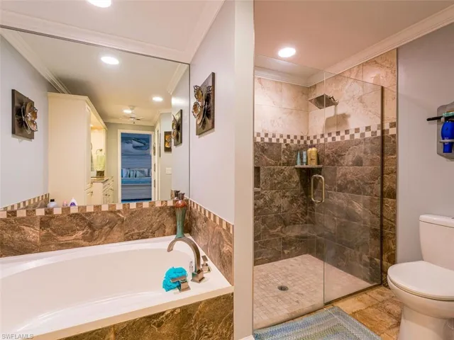 Bathroom with tile floors, crown molding, plus walk in shower, and toilet