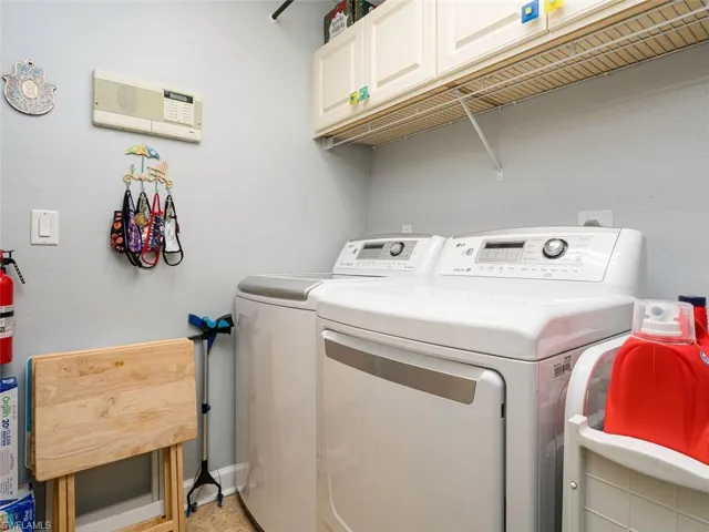 Washroom with separate washer and dryer and cabinets