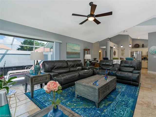 Tiled living room with vaulted ceiling and ceiling fan