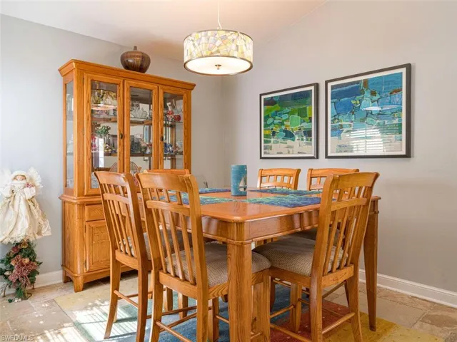 Tiled dining room featuring lofted ceiling