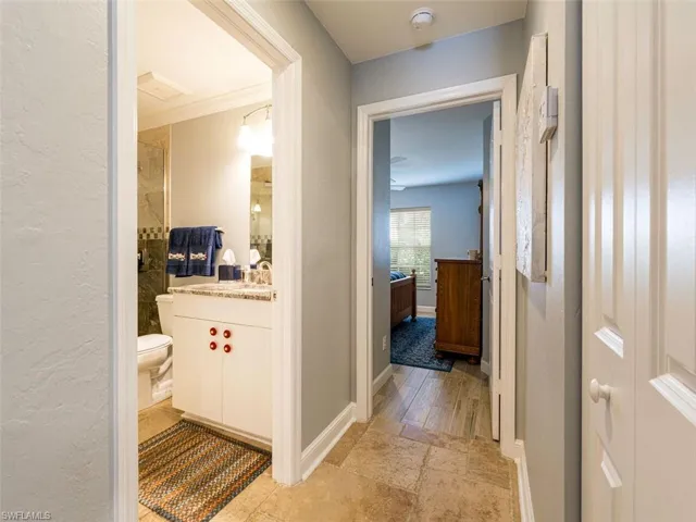 Corridor with ornamental molding and light tile flooring