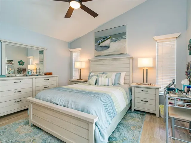 Bedroom with ceiling fan, vaulted ceiling, and light hardwood / wood-style flooring