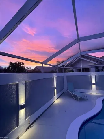 Patio terrace at dusk featuring a pool and a lanai
