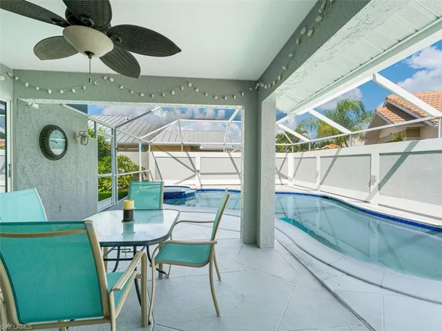 View of swimming pool featuring ceiling fan, a lanai, and a patio area