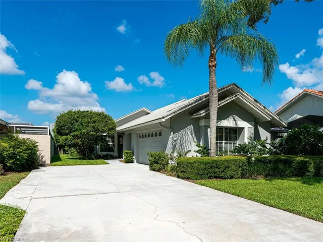 View of front facade featuring a front lawn and a garage