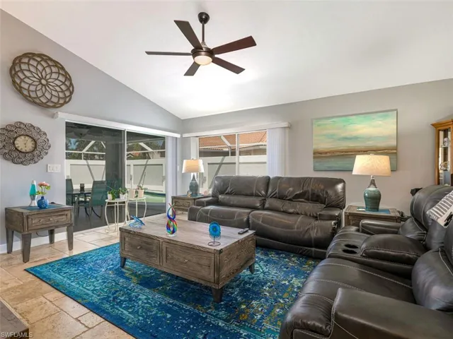 Living room with tile flooring, ceiling fan, and lofted ceiling