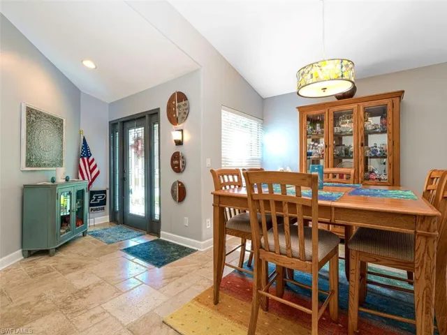 Dining area with light tile floors and lofted ceiling