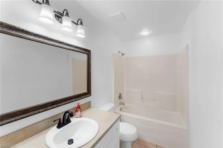 Full bathroom featuring tile patterned flooring, shower / bathing tub combination, toilet, and vanity