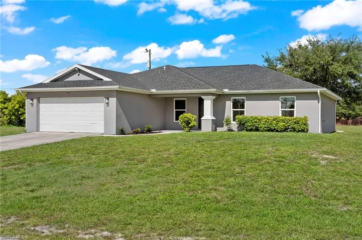 Ranch-style home with a garage and a front lawn