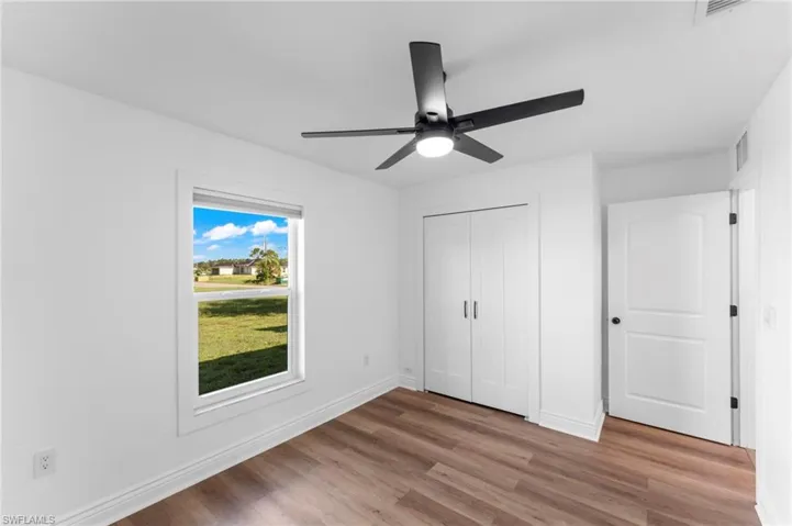 Unfurnished bedroom with wood-type flooring, a closet, and ceiling fan
