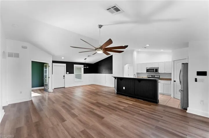 Kitchen featuring ceiling fan, light hardwood / wood-style flooring, stainless steel appliances, and vaulted ceiling