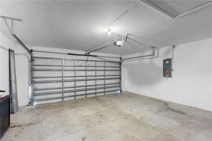 Garage with electric panel and a garage door opener