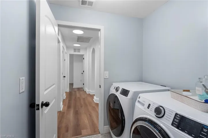Washroom with washer and dryer and hardwood / wood-style floors