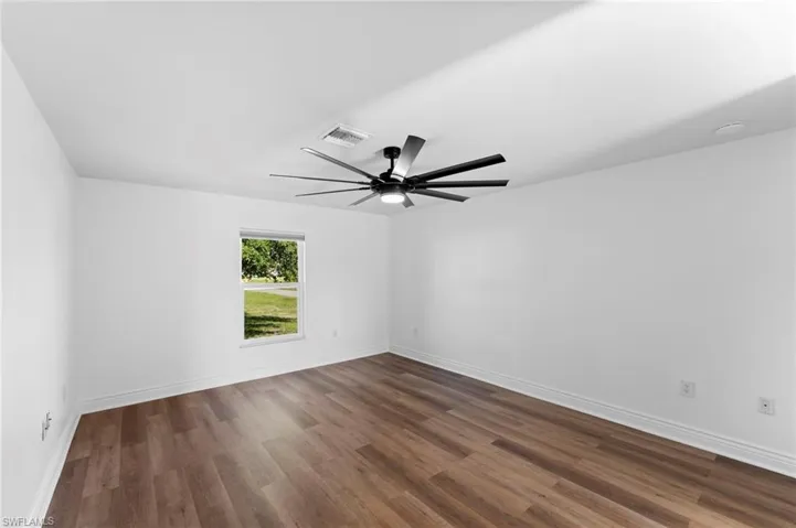 Spare room featuring dark hardwood / wood-style flooring and ceiling fan