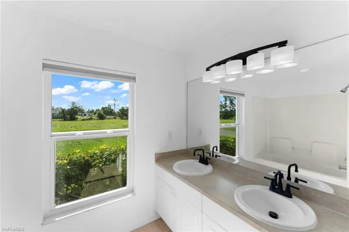 Bathroom with double vanity and a healthy amount of sunlight