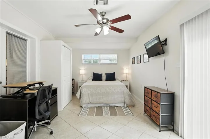 Bedroom featuring light tile patterned floors and ceiling fan