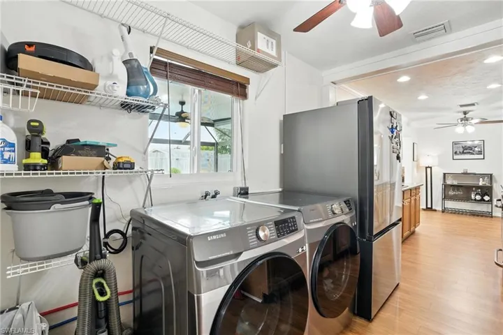 Washroom featuring a ceiling fan, light wood finished floors, washing machine and dryer, and recessed lighting