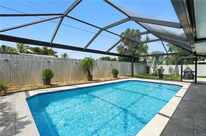 View of pool with a fenced backyard, a patio area, and a lanai