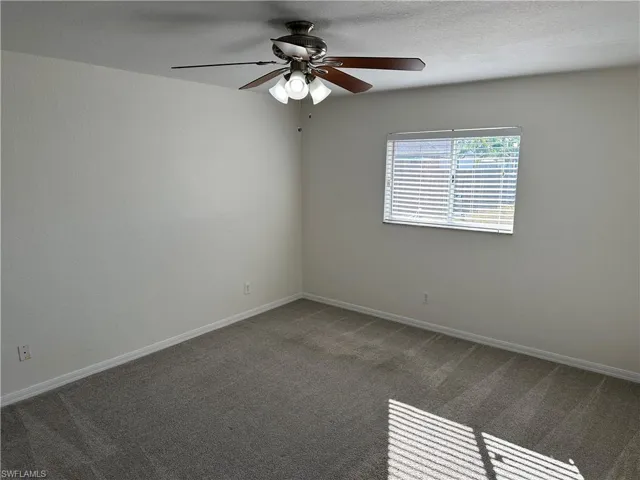 Carpeted spare room with ceiling fan