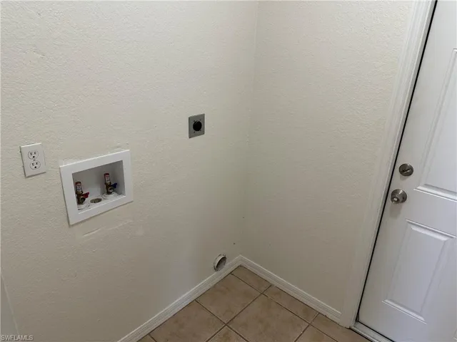 Laundry room featuring hookup for a washing machine, light tile patterned floors, and hookup for an electric dryer