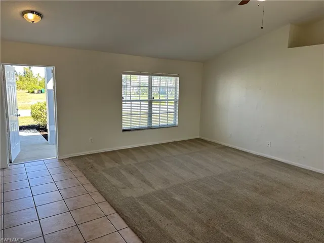 Carpeted empty room featuring ceiling fan