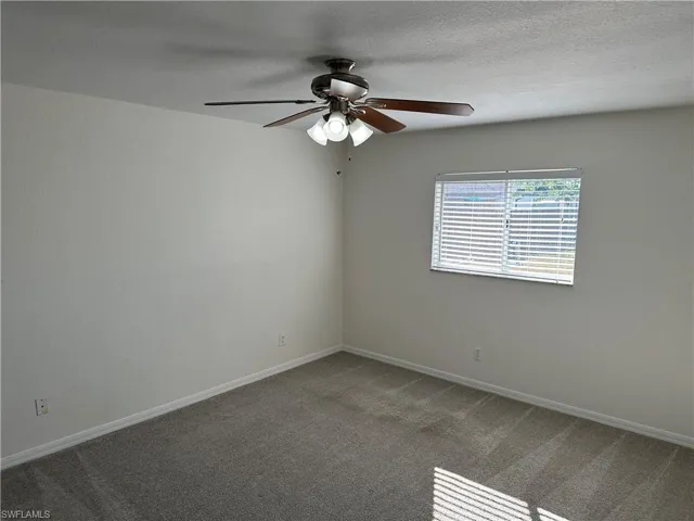 Unfurnished room with ceiling fan and carpet floors