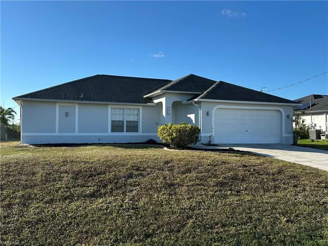 Ranch-style house with a garage, a front lawn, and central air condition unit