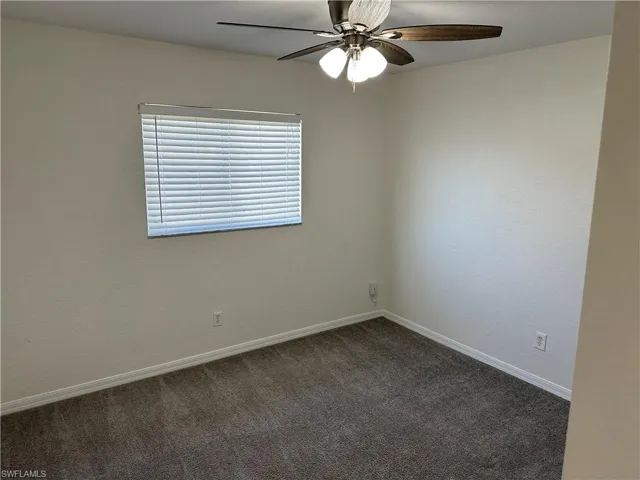 Carpeted spare room with ceiling fan