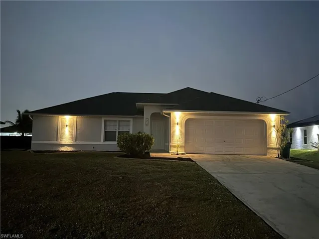 Ranch-style house with a garage and a front yard
