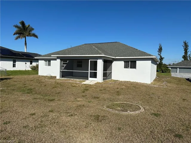 Rear view of house with a sunroom and a yard