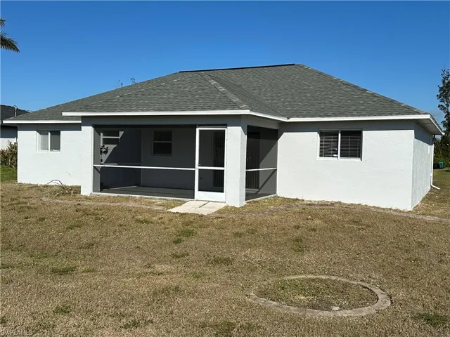 Back of house with a yard and a sunroom