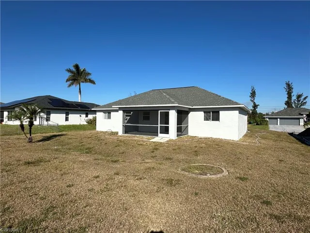 Back of house with a lawn and a sunroom
